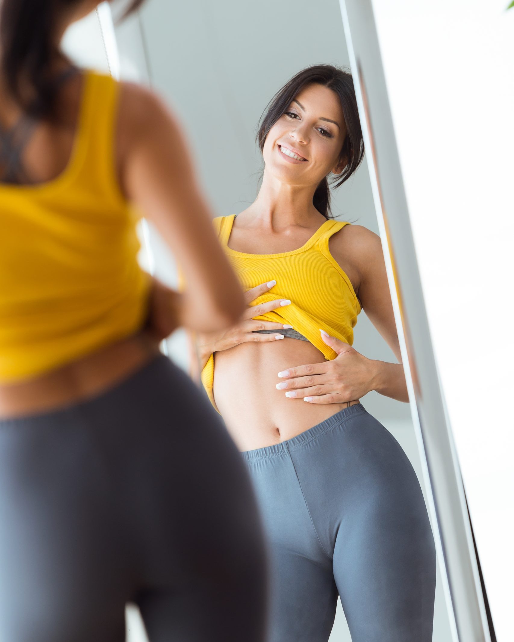 beautiful young woman looking herself reflection in mirror at ho